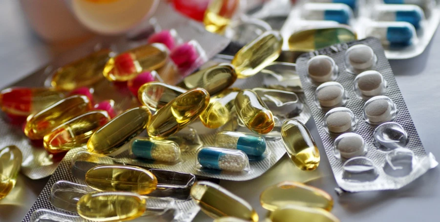 a bunch of pills sitting on top of a table, a picture, by Bernard Meninsky, pexels, plasticien, shields, macro up view metallic, various colors, photograph credit: ap