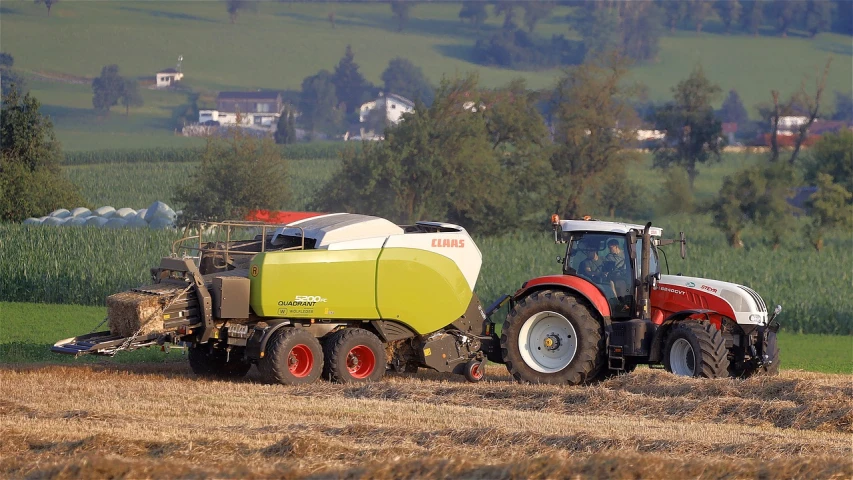 a tractor pulling a trailer behind it in a field, a picture, by Edwin Georgi, flickr, figuration libre, panorama, swiss, ball, organic biomass
