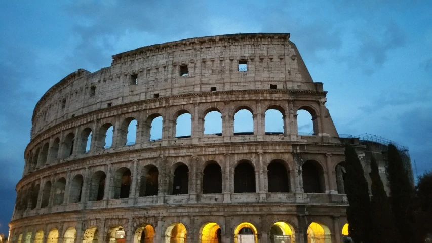 the roman colossion is lit up at night, a picture, by Tom Wänerstrand, photo taken with an iphone, golden hour, in a coliseum, yummy