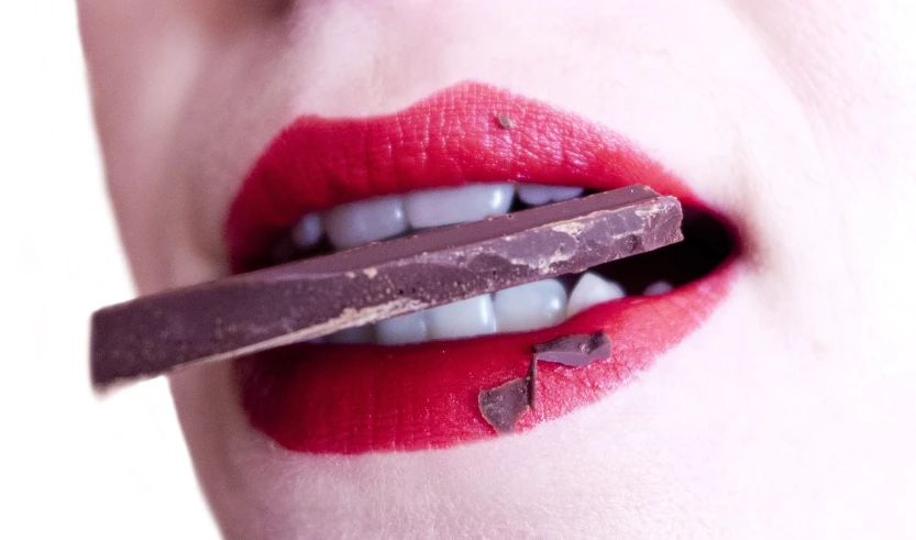 a close up of a person eating a piece of chocolate, a picture, pexels, hyperrealism, light-red lips, avatar image, closeup of an adorable, rectangular
