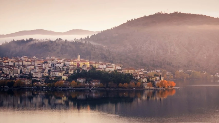 a large body of water with a mountain in the background, a picture, by Luca Zontini, pexels contest winner, romanticism, beautiful small town, in muted colours, :: morning, autum