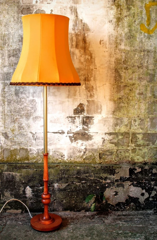 a lamp sitting on top of a wooden floor next to a wall, by Niels Lergaard, baroque, yellow and ornage color scheme, wooden staff, vintage old, standing lamp luxury