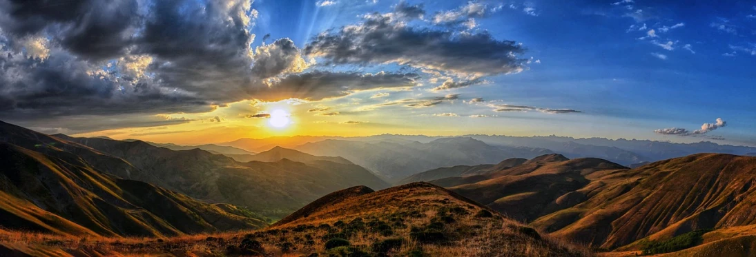 the sun is setting over a mountain range, a picture, pexels, renaissance, rolling hills, hdr colors, sunburst, wikimedia commons