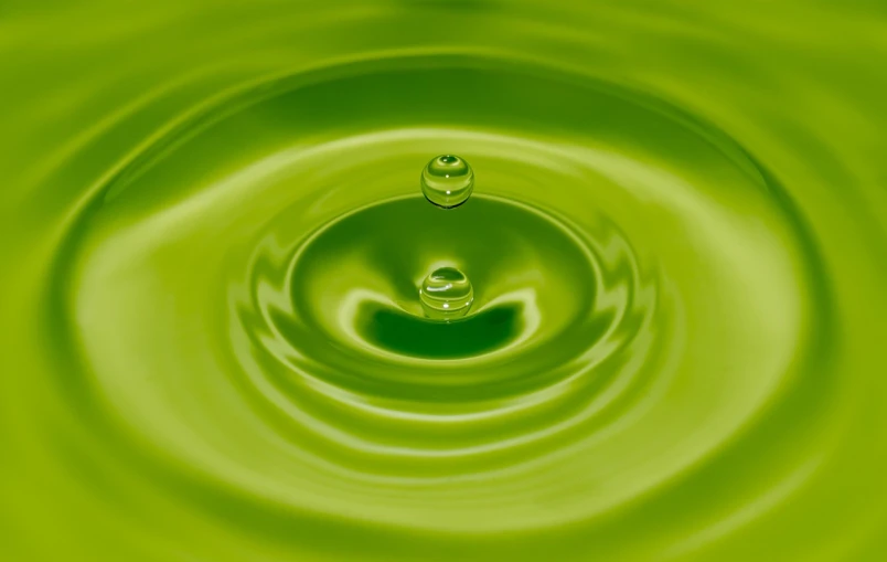 a close up of a green water drop, a digital rendering, minimalism, rippling liquid, istockphoto, feng shui, juice