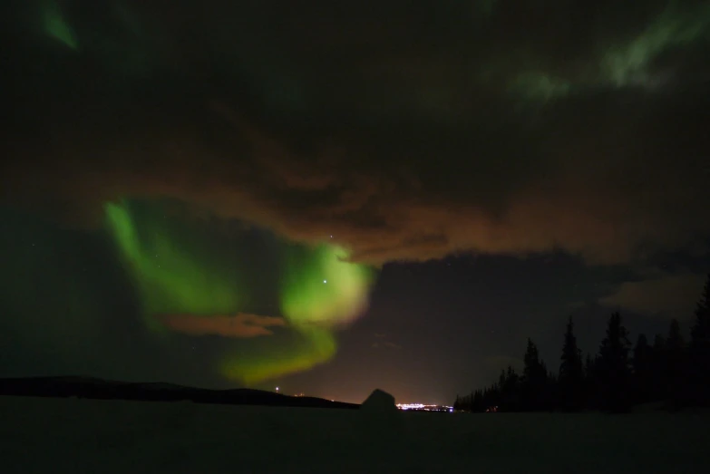 the aurora bore lights up the night sky, a picture, by Sigrid Hjertén, flickr, hurufiyya, undulating nebulous clouds, distant town lights, koyaanisqatsi, video still