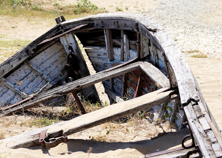 a wooden boat sitting on top of a sandy beach, a picture, by Alexander Fedosav, renaissance, deteriorated, detailed zoom photo, water wheel, tourist photo