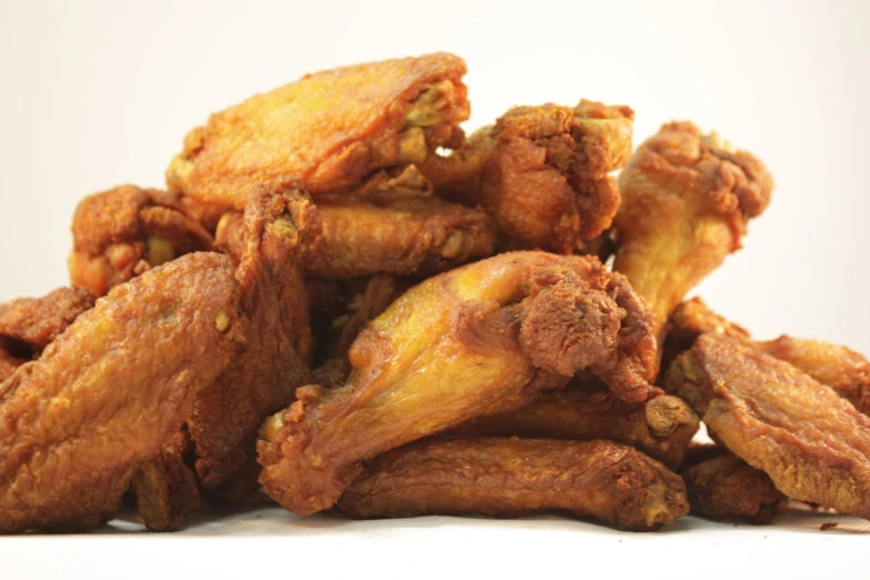 a pile of fried chicken sitting on top of a table, by Linda Sutton, large wings on back, close up angle, white, -h 1024