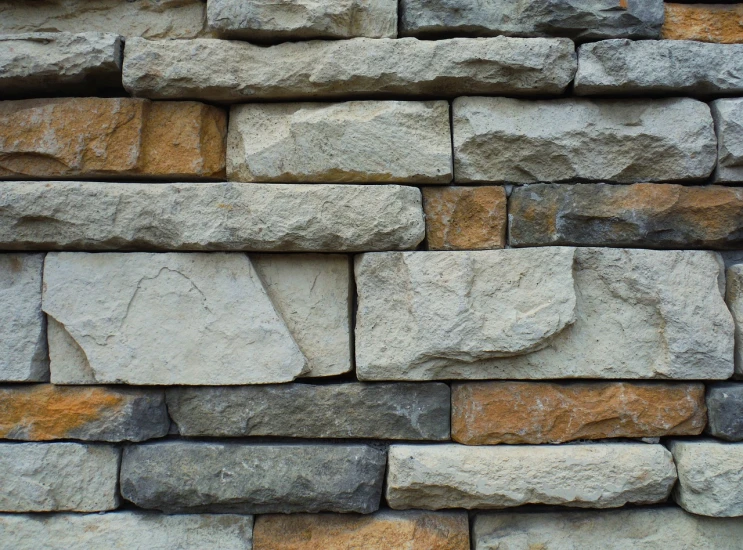 a close up view of a stone wall, by Bernardino Mei, pexels, modernism, earth tones and blues, cinder blocks, a handsome, stacked