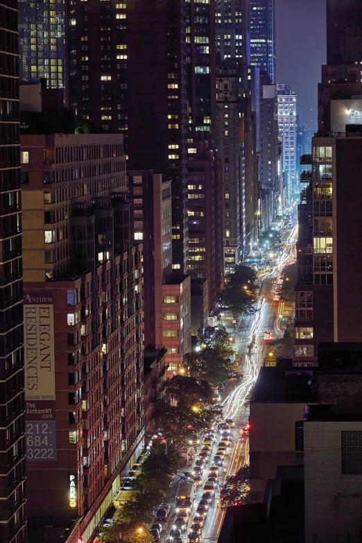 a city street filled with lots of traffic next to tall buildings, a picture, by Alexander Robertson, new york city at night, high vantage point, mid shot photo, 3 4 5 3 1