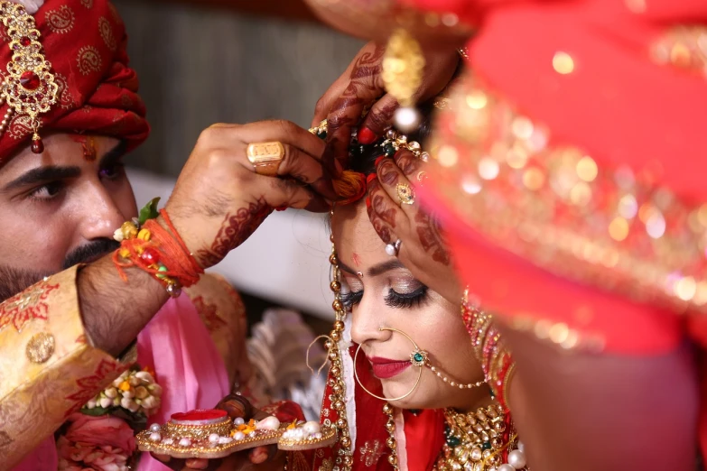 a man putting a ring on a woman's forehead, by Rajesh Soni, red color theme, full head shot, video footage, rustic