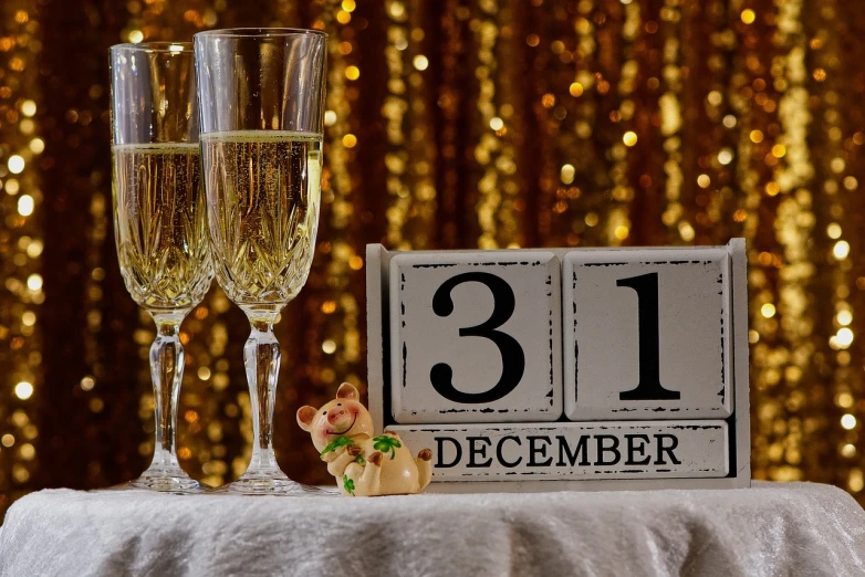 a couple of champagne glasses sitting on top of a table, a picture, by Daphne Allen, pixabay, happening, countdown, number 31 on jersey, yellowing wallpaper, christmas night