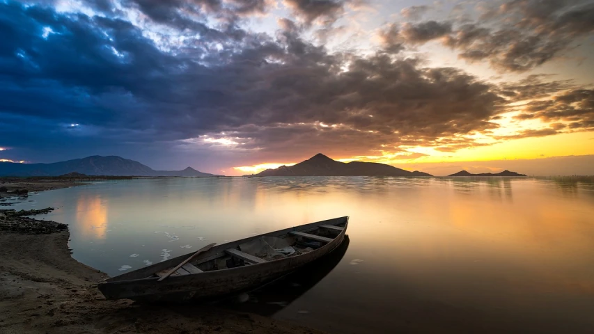 a boat sitting on top of a beach next to a body of water, a picture, by Niklaus Manuel, shutterstock contest winner, romanticism, cloudy sunset, vertical wallpaper, on the calm lake, mountain