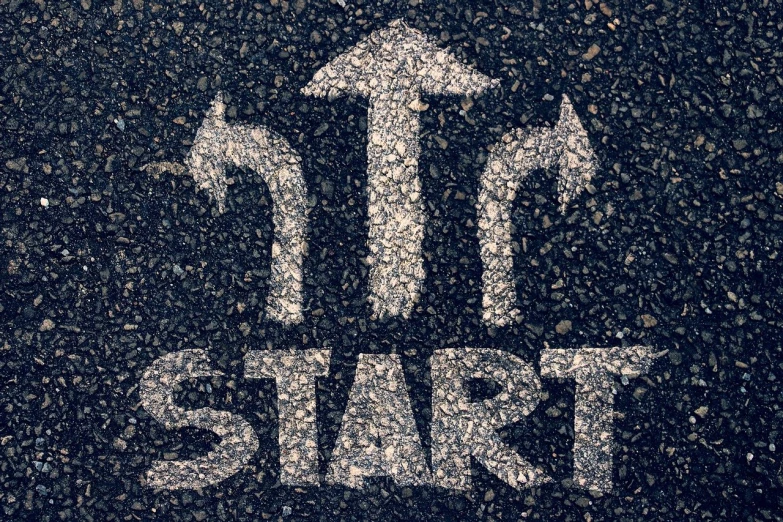 a close up of a street sign with arrows, trending on pixabay, street art, start, start of the match, paved, in teh style of tony start
