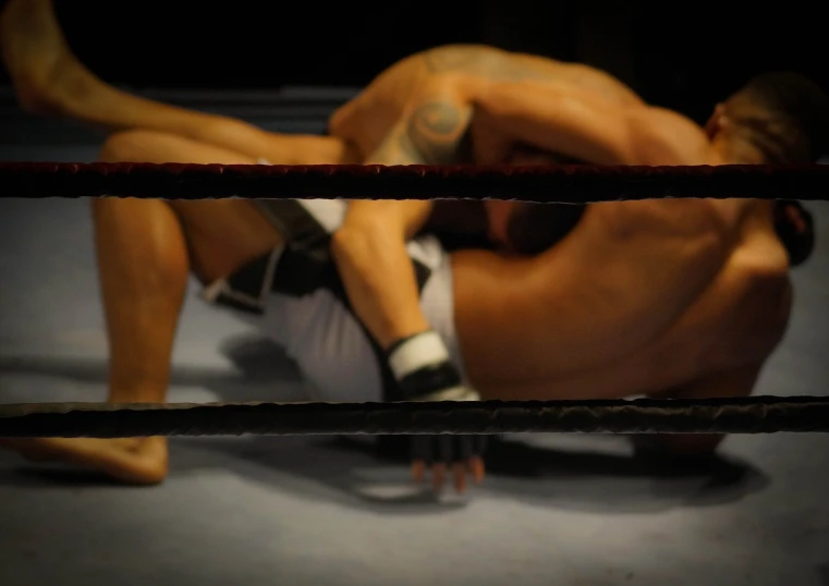 a man laying on the ground in a boxing ring, a picture, figuration libre, muscular men entwined together, ultimate fighting championship, slightly erotic, pinned down