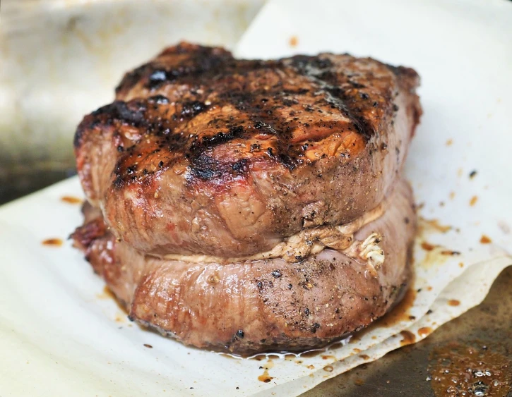 a steak sitting on top of a piece of paper, by Joe Bowler, bottom body close up, food photo, thick lining, cooked