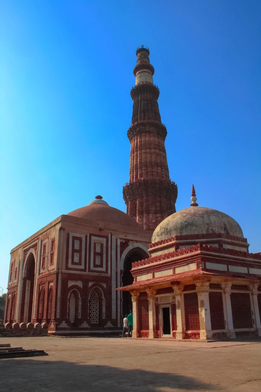 a red and white building with a clock tower, a picture, ancient india, tourist photo, tombs, sunny day with clear sky