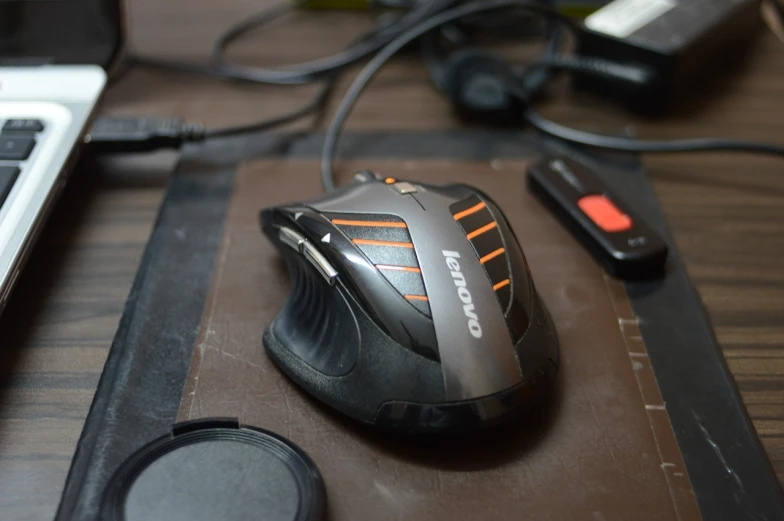 a computer mouse sitting on top of a wooden desk, by Daryush Shokof, reddit, cobra, black and orange, 6 claws, braavos, hdd