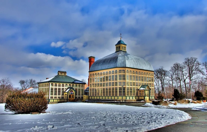 a large building sitting on top of a snow covered field, a photo, by Tom Carapic, pixabay, art nouveau, in bloom greenhouse, rhode island, with great domes and arches, hdr shot