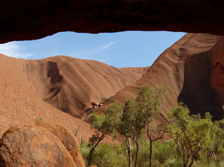 a man that is standing in the dirt, a cave painting, inspired by Albert Namatjira, pexels contest winner, window view, massive arch, as seen from the canopy, dune