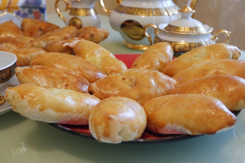 a close up of a plate of doughnuts on a table, by Amédée Ozenfant, hurufiyya, mixture turkish and russian, potato skin, stuffed, loaves