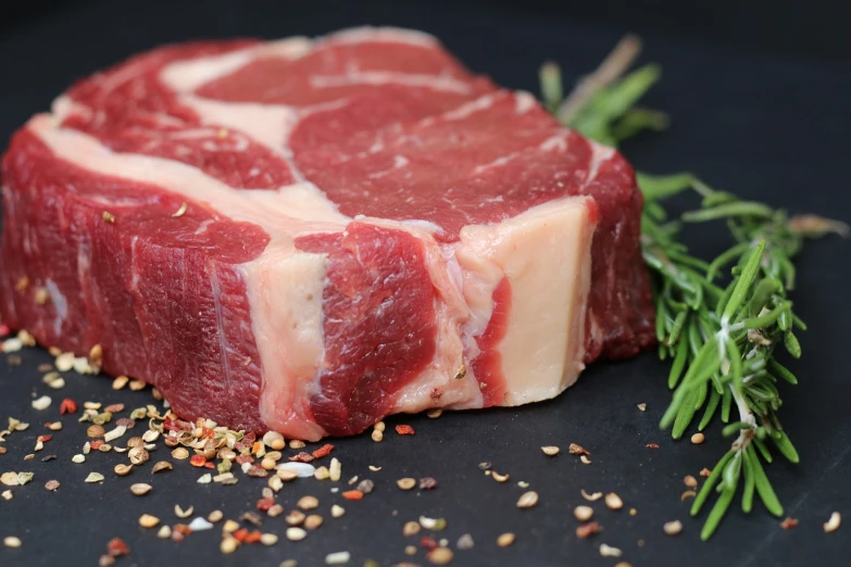 a piece of meat on a plate with a sprig of rosemary, a picture, by Julian Hatton, pixabay, thick neck, huge glistening muscles, 4yr old, cow