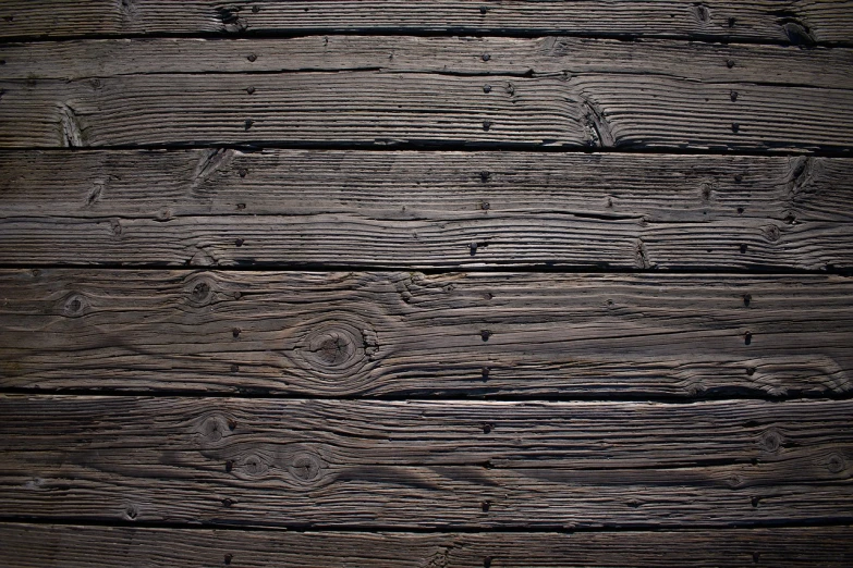 a close up of a piece of wood, a stock photo, by Jakob Häne, shutterstock, minimalism, dark grey, on a pirate ship background, pinned joints, old wood floors