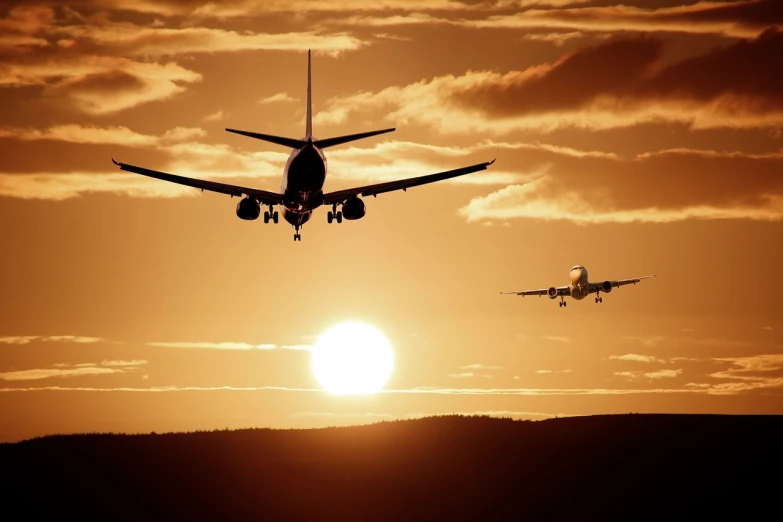 a couple of planes that are flying in the sky, pixabay, sunset in the distance, runway photo, air is being pushed around him, in the sun
