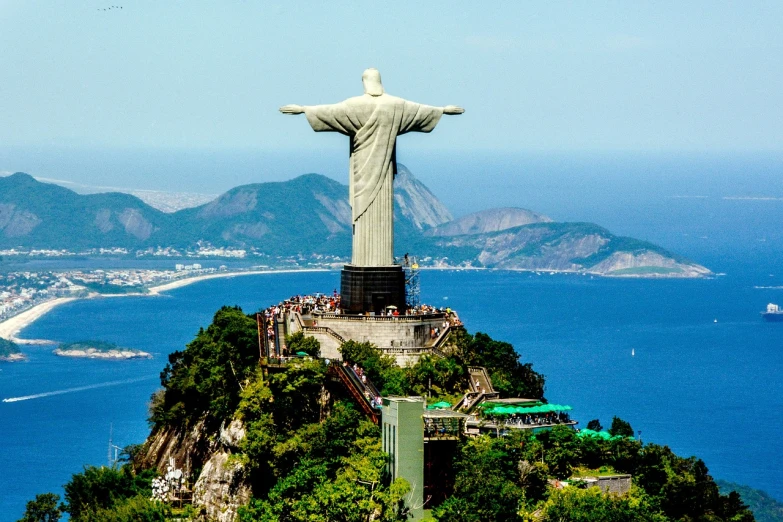 a statue on top of a mountain overlooking a body of water, a statue, by Felipe Seade, shutterstock, cristo redentor, “ aerial view of a mountain, usa-sep 20, carnival