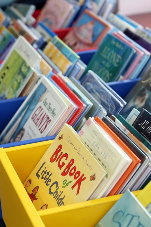 a yellow bin filled with lots of children's books, a picture, by Tom Carapic, pixabay, bottom angle, library of congress, carnival, eric carle