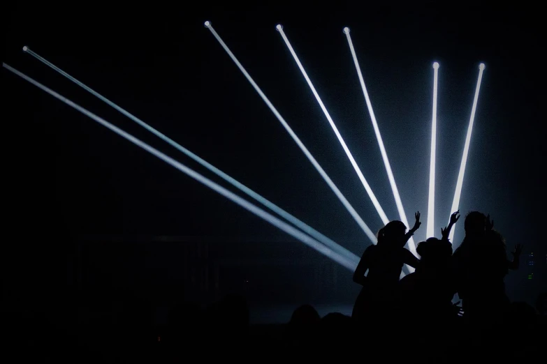 a group of people standing on top of a stage, by Ottó Baditz, unsplash, light and space, lasers for lights, black silhouette, minimalist lighting, still from a music video