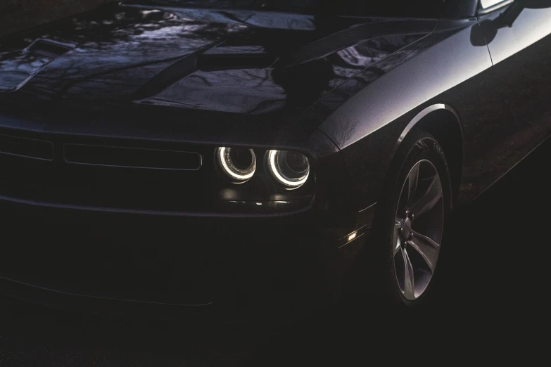 a black car parked on the side of the road, by Matt Cavotta, pexels contest winner, photorealism, headlights, muscle, bright halo, medium close-up shot