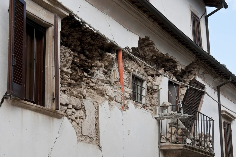 a building that has a bunch of rubble on the side of it, a photo, by Alessandro Galli Bibiena, shutterstock, large cracks, rice, 2 0 1 0 photo, looking partly to the left