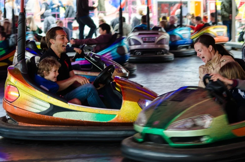 a group of people riding bumper cars down a street, a portrait, by Lee Loughridge, shutterstock, amusement park interior design, families playing, square, automotive
