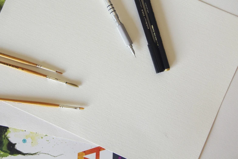 a couple of pens sitting on top of a piece of paper, a minimalist painting, academic art, miniature product photo, banner, unfinished canvas, product introduction photo