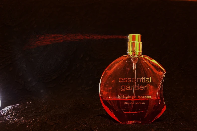 a bottle of perfume sitting on the ground, inspired by Hans Erni, “ sensual, eden garden, header, glowing red