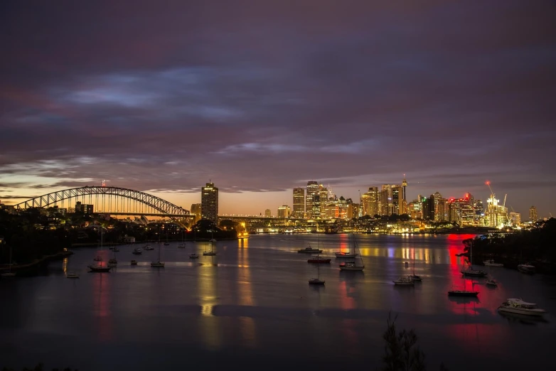 a harbor filled with lots of boats under a cloudy sky, a picture, inspired by Sydney Carline, pexels, australian tonalism, night cityscape, skyline showing, an ancient, tony roberts