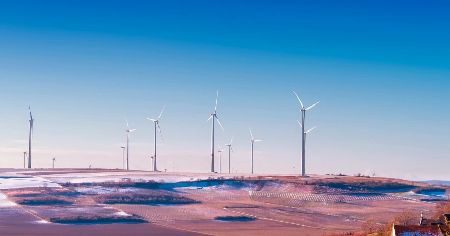 a group of wind turbines sitting on top of a hill, a colorized photo, unsplash, surrealism, sunny winter day, pc screen image, beijing, panorama