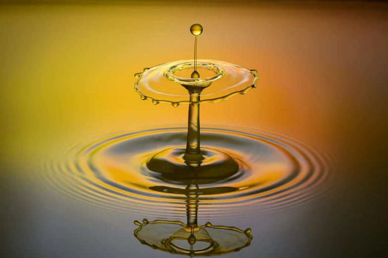a drop of water falling into a body of water, a macro photograph, art photography, stacked image, gradient yellow, beautifully symmetrical, water fountain