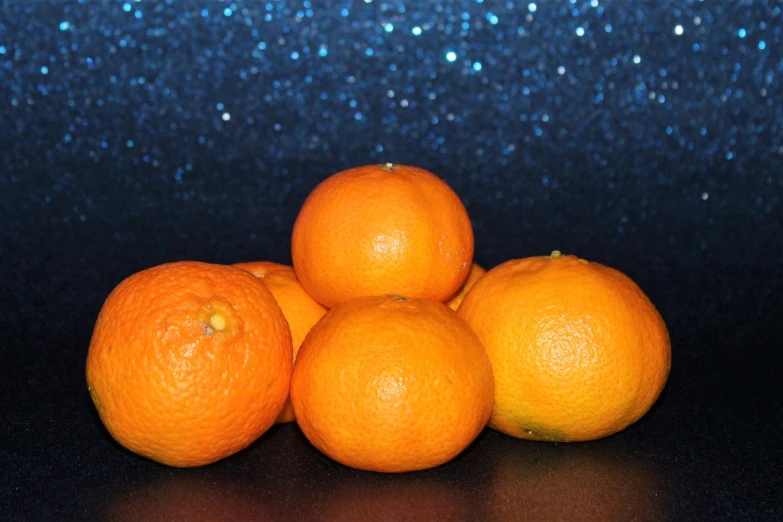 a pile of oranges sitting on top of a table, a still life, by Juan O'Gorman, trending on pixabay, perfect crisp moonlight, profile pic, miniature product photo, blue and orange lighting