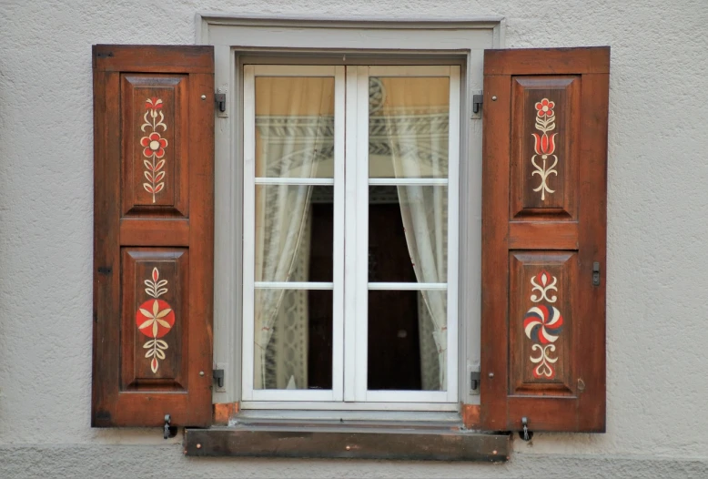 a decorative window with two windows with curtains