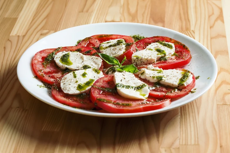 a white plate topped with sliced tomatoes and mozzarella, a stock photo, shutterstock, food photograph, high detail product photo, mint, vinesauce