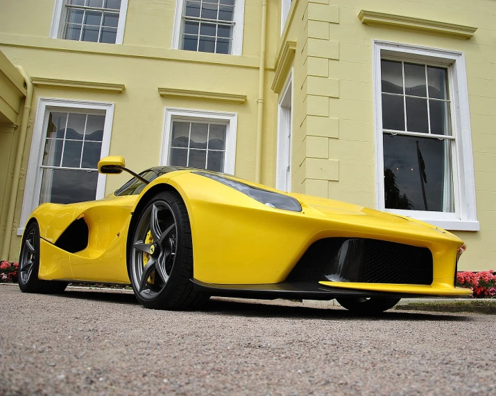 a yellow sports car parked in front of a yellow house, a picture, inspired by Bernardo Cavallino, tumblr, synthetism, f50, sleek flowing shapes, huge gargantuan scale, riding on a prancing horse