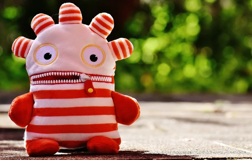 a close up of a stuffed animal wearing a sweater, inspired by Wilson Irvine, pixabay contest winner, red and white stripes, graffiti monster, vinyl toy figurine, summer evening