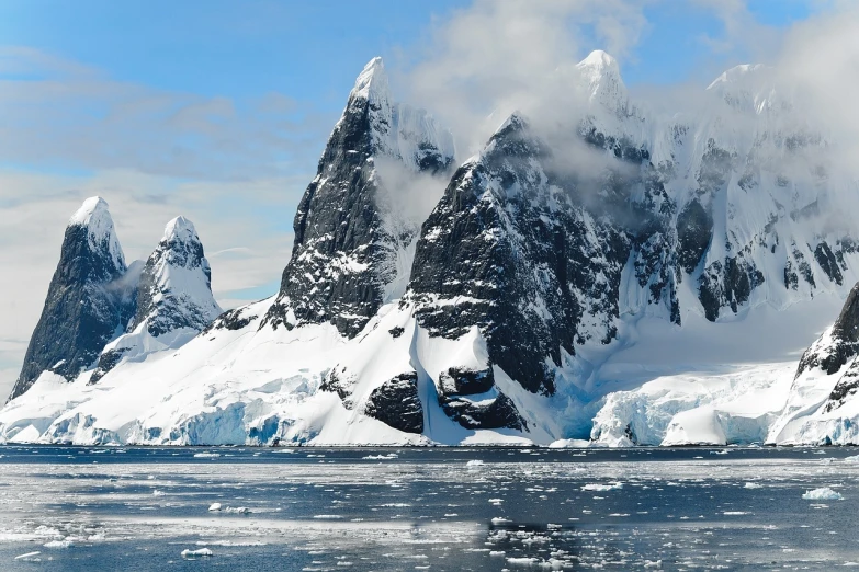 a mountain covered in snow next to a body of water, shutterstock, antarctic, devils horns, wikimedia commons, pillars of ice background