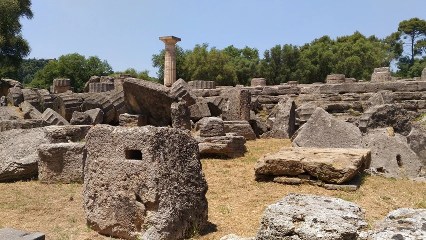 a large pile of rocks sitting on top of a grass covered field, huge greek columns, olympus platform, from italica, banner