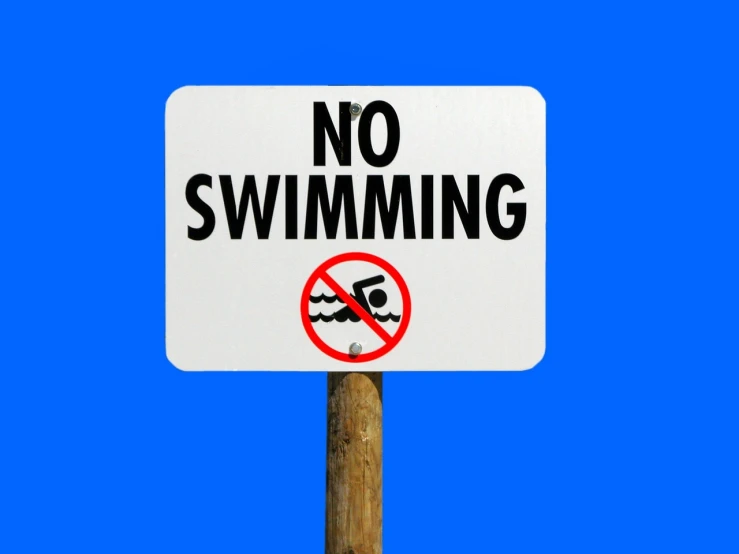 a no swimming sign on a pole against a blue sky, a photo, by Whitney Sherman, shutterstock, wallpaper”, shiny skin”, sinking underwater, marker”
