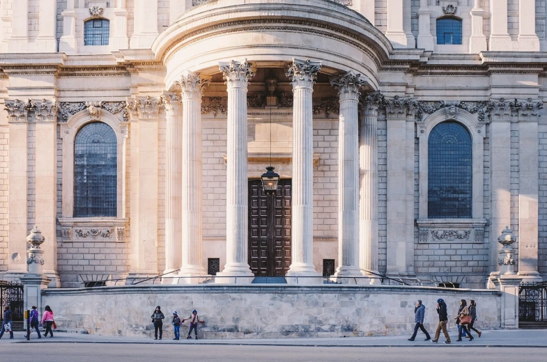 a group of people walking in front of a building, a photo, inspired by Christopher Wren, shutterstock, fine art, cinematic morning light, holy place, high quality photos, architecture carved for a titan