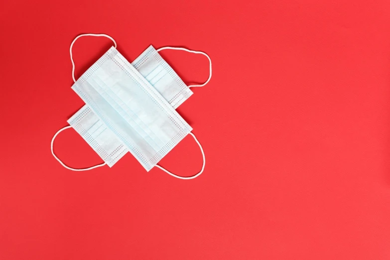 a pair of face masks on a red surface, a stock photo, red cross, 3 - piece, product photo, symmetrically