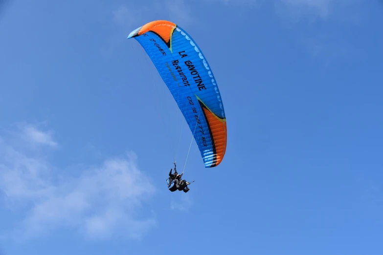 a person that is flying a kite in the sky, a picture, by Werner Gutzeit, flickr, blue!! with orange details, breitling, riding, canopy