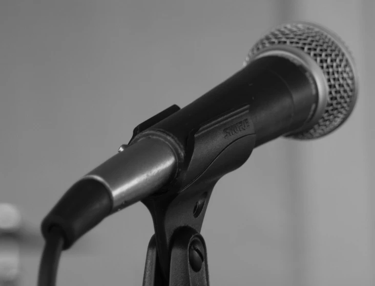 a close up of a microphone on a stand, by Steven Belledin, happening, black and white photo.iso200, side - view, banner, taken with a pentax1000